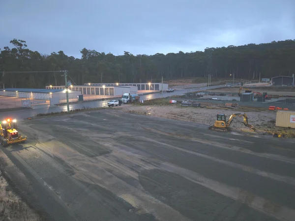 Roller compacting a pad at dusk on a subdivision site